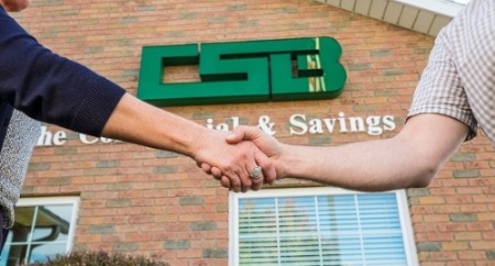 Image of people shaking hands in-front of a banking center