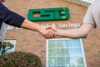 Image of people shaking hands in-front of a banking center