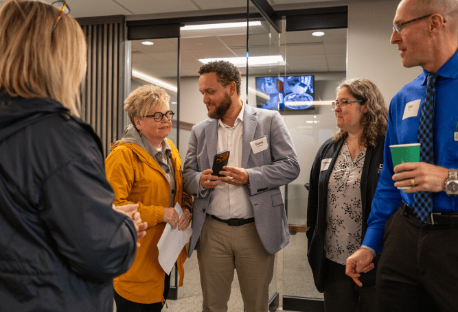 Professionals connect and converse during a networking event at a Commercial & Savings Bank location.