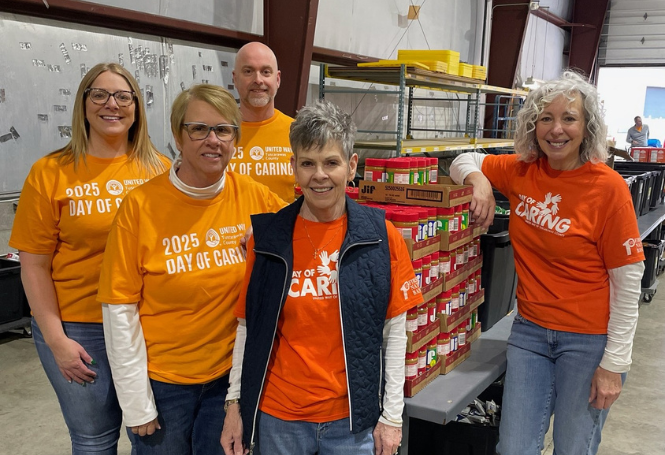 Group of CSB employees wearing orange 'Day of Caring' shirts at a volunteer event.