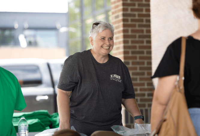 A Commercial & Savings Bank employee greets attendees at a community event.
