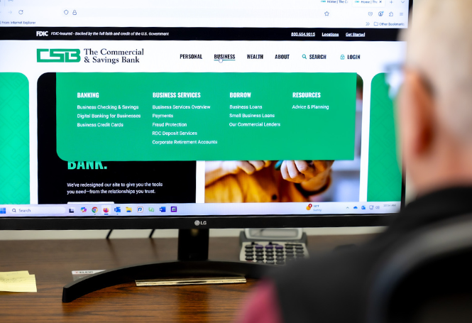 Person browsing CSB website business services dropdown on desktop.