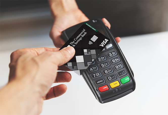 Customer tapping black CSB credit card on payment terminal for purchase.