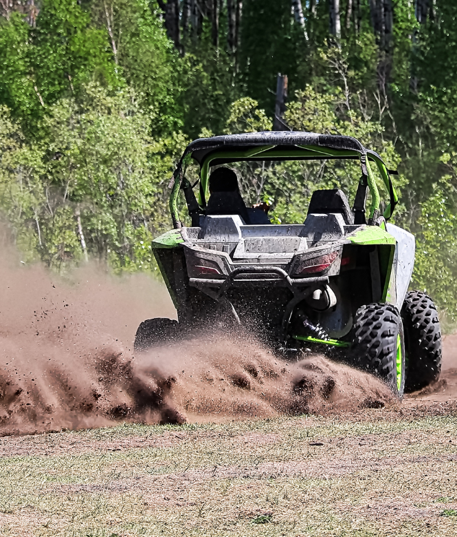 UTV kicking up dirt while speeding through an open field