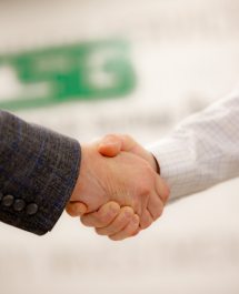 Two people shaking hands in front of CSB branded wall.