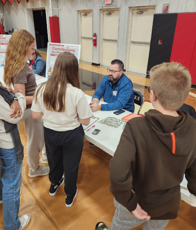 CSB employee talking to students at a financial literacy event.