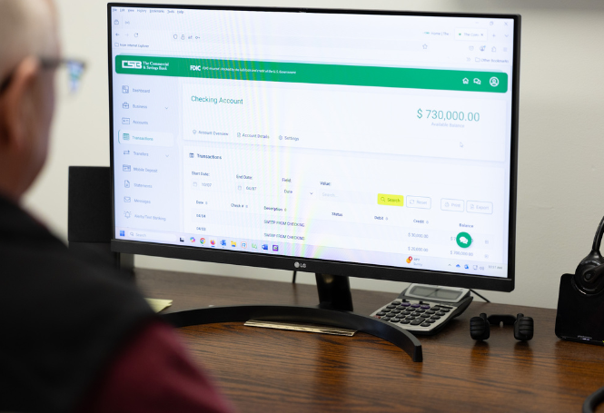 Person viewing CSB online banking dashboard on desktop monitor.